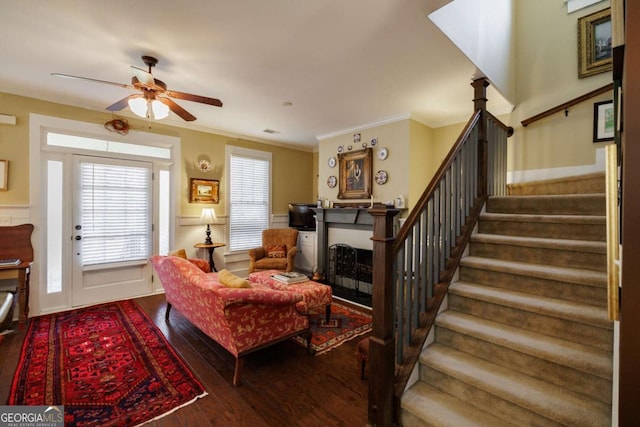 living room featuring hardwood / wood-style floors, crown molding, and ceiling fan