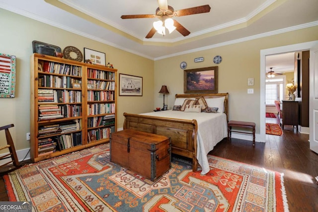 bedroom with dark hardwood / wood-style flooring, crown molding, and a raised ceiling