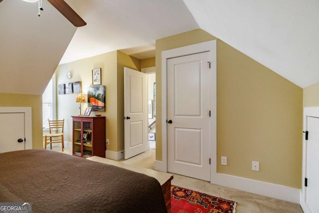 bedroom with ceiling fan, lofted ceiling, and light carpet