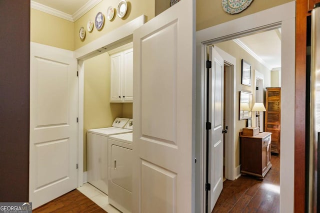 washroom featuring separate washer and dryer, crown molding, dark hardwood / wood-style flooring, and cabinets