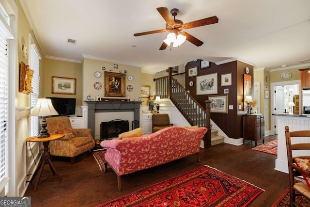 living room featuring crown molding, wood-type flooring, and ceiling fan