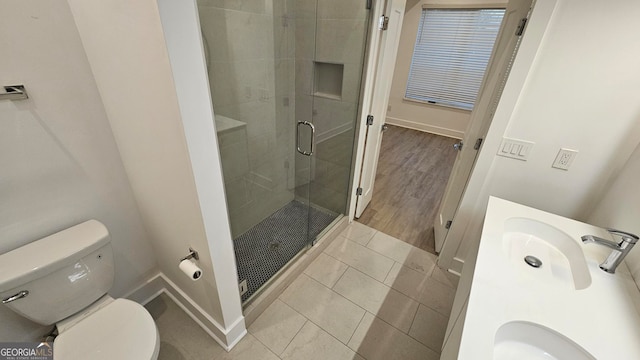 bathroom featuring vanity, tile patterned flooring, a shower with shower door, and toilet