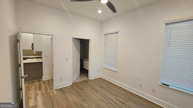 unfurnished bedroom with ensuite bath, light hardwood / wood-style flooring, and ceiling fan