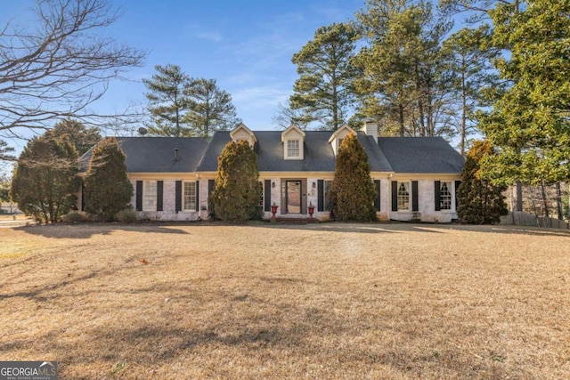 cape cod home with a front lawn