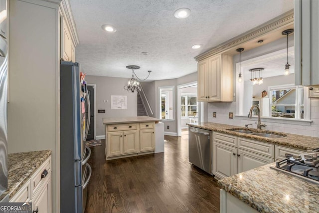 kitchen featuring stainless steel appliances, sink, dark wood-type flooring, and decorative light fixtures