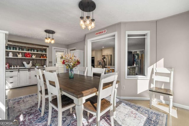 dining area featuring a textured ceiling, tile patterned floors, and a chandelier