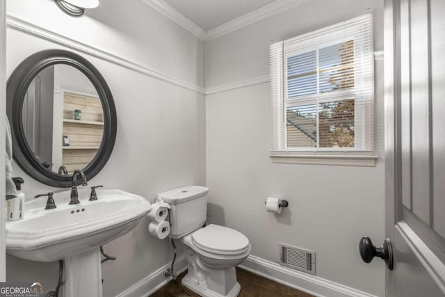 bathroom with ornamental molding, toilet, sink, and wood-type flooring