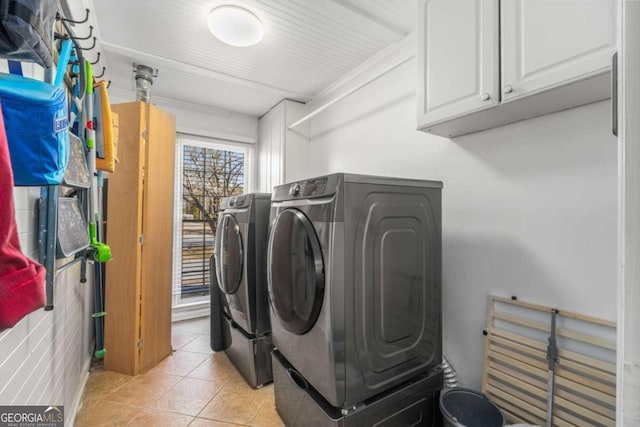 clothes washing area featuring cabinets, independent washer and dryer, and light tile patterned flooring