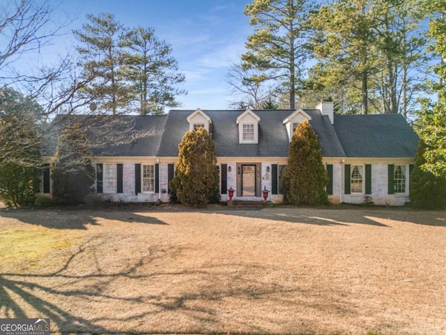 cape cod-style house featuring a front yard