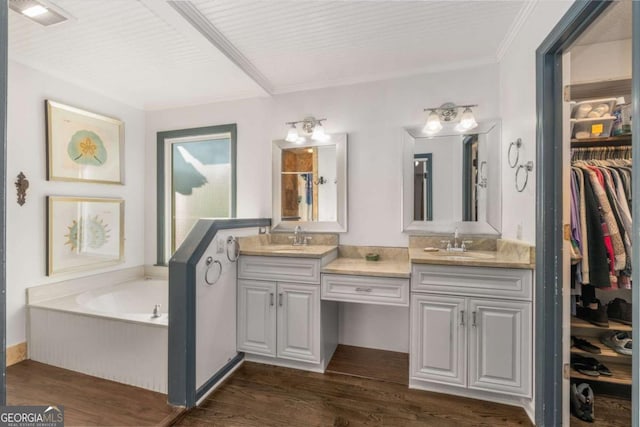 bathroom featuring vanity, hardwood / wood-style floors, a washtub, and crown molding