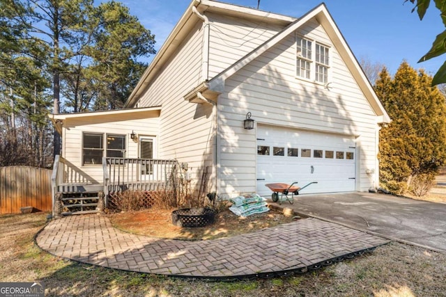 back of house with a fire pit and a deck