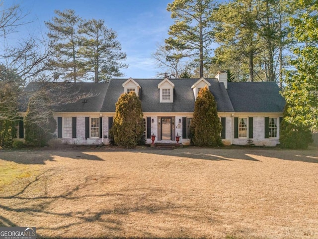 cape cod house with a front yard