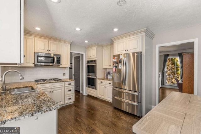 kitchen with sink, tasteful backsplash, dark hardwood / wood-style flooring, stone counters, and stainless steel appliances