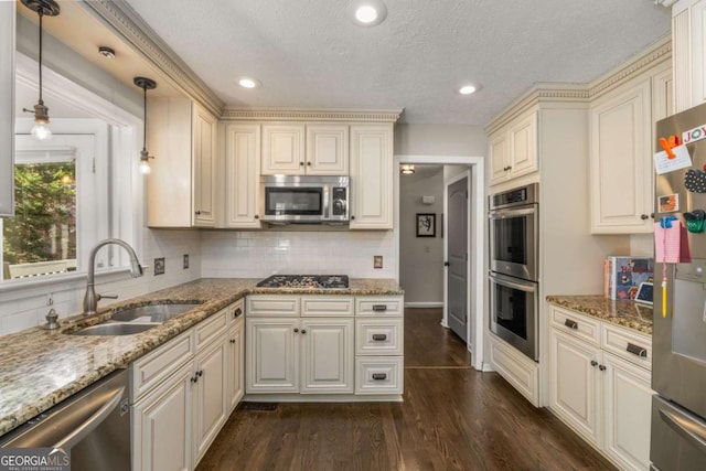 kitchen featuring sink, stone counters, stainless steel appliances, dark hardwood / wood-style flooring, and decorative light fixtures