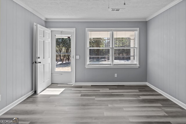 entryway featuring crown molding, light hardwood / wood-style floors, and a textured ceiling