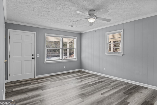 757 Sparta Hwy, Eatonton, GA 31024 - unfurnished room with plenty of natural light, a textured ceiling, crown molding, wood finished floors, and a ceiling fan