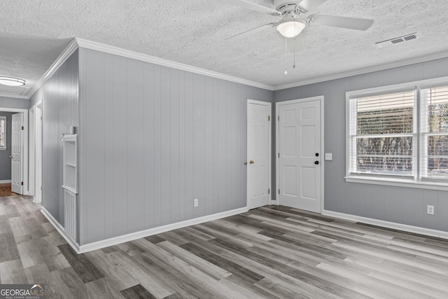 spare room featuring crown molding, hardwood / wood-style flooring, a textured ceiling, and ceiling fan