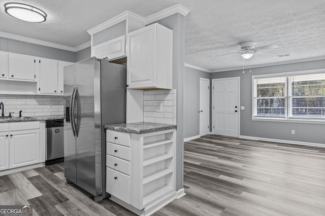 kitchen with sink, crown molding, dark wood-type flooring, appliances with stainless steel finishes, and white cabinets