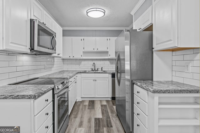 757 Sparta Hwy, Eatonton, GA 31024 - kitchen with appliances with stainless steel finishes, open shelves, a textured ceiling, a sink, and wood finished floors