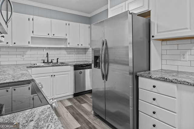 kitchen with stainless steel appliances, white cabinetry, sink, and ornamental molding