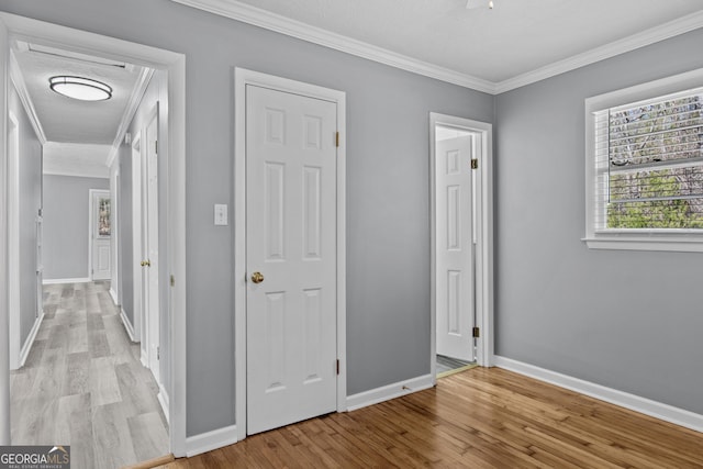 hallway featuring crown molding and light wood-type flooring