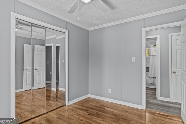 unfurnished bedroom featuring hardwood / wood-style floors, crown molding, a textured ceiling, and ceiling fan