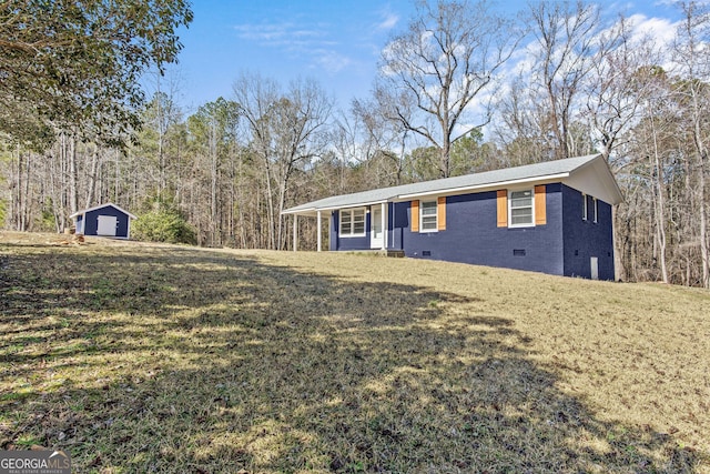 ranch-style house featuring a storage unit and a front lawn