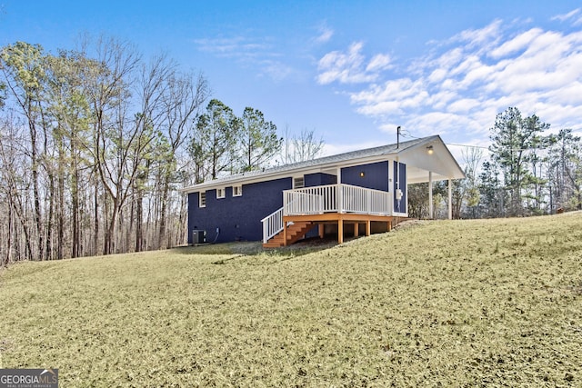 rear view of house with a yard and a deck