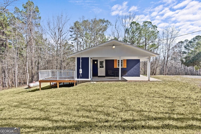 view of front of home featuring a patio, a front yard, and a deck