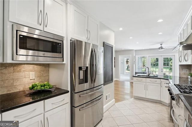 kitchen with decorative backsplash, light tile patterned flooring, white cabinets, and appliances with stainless steel finishes