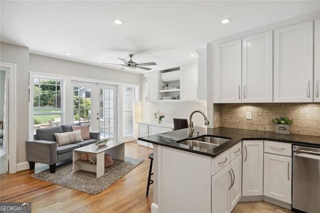 kitchen featuring kitchen peninsula, sink, dishwasher, and white cabinets