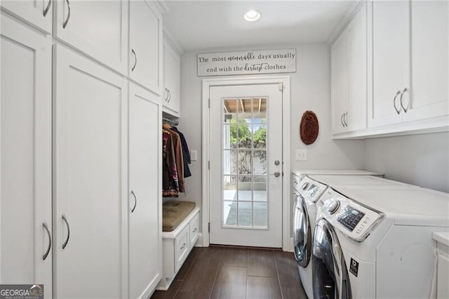 washroom featuring cabinets, washing machine and dryer, and dark hardwood / wood-style floors