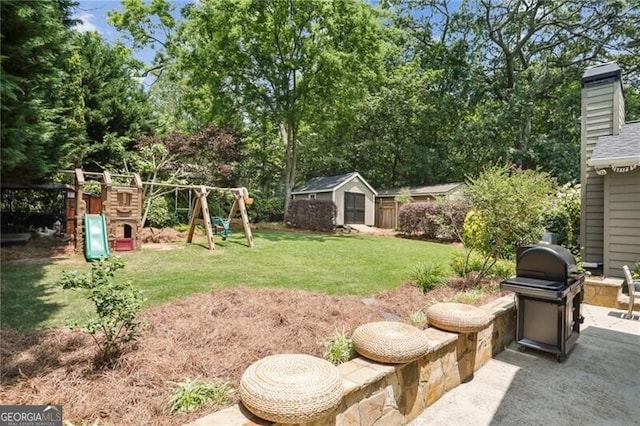 view of yard featuring a playground, a patio area, and a storage shed