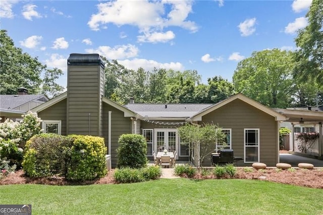 rear view of property featuring a patio, a yard, and french doors