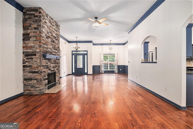2753 Jubilee Ter, Bethlehem, GA 30620 - unfurnished living room with a ceiling fan, ornamental molding, wood finished floors, a stone fireplace, and arched walkways