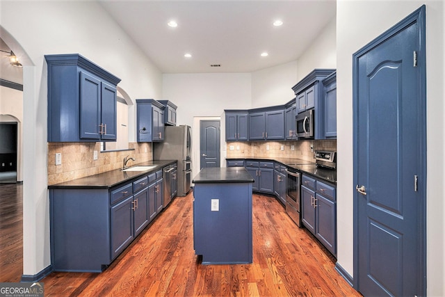 2753 Jubilee Ter, Bethlehem, GA 30620 - kitchen with appliances with stainless steel finishes, dark countertops, arched walkways, a kitchen island, and backsplash