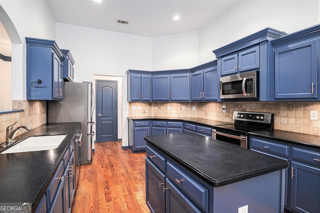 2753 Jubilee Ter, Bethlehem, GA 30620 - kitchen featuring stainless steel appliances, arched walkways, light wood-style floors, backsplash, and dark countertops