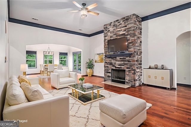 2753 Jubilee Ter, Bethlehem, GA 30620 - living area featuring arched walkways, ceiling fan, wood finished floors, a stone fireplace, and ornamental molding