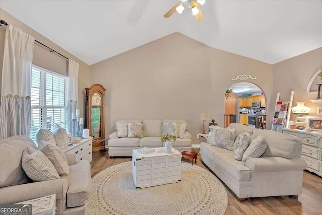 living room featuring ceiling fan, lofted ceiling, and light hardwood / wood-style floors