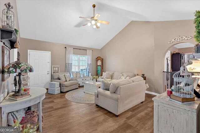 living room featuring wood-type flooring, high vaulted ceiling, and ceiling fan