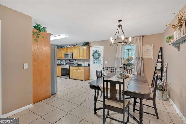 dining space with light tile patterned floors and a chandelier