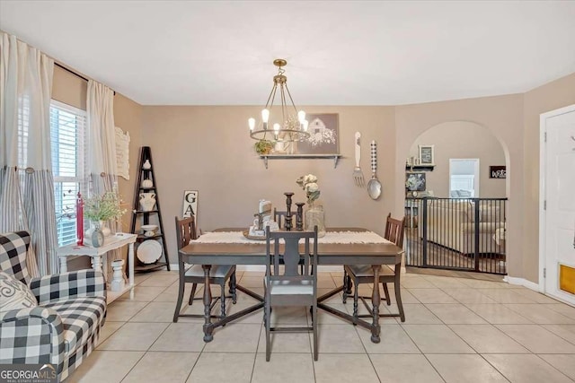 tiled dining space featuring a notable chandelier