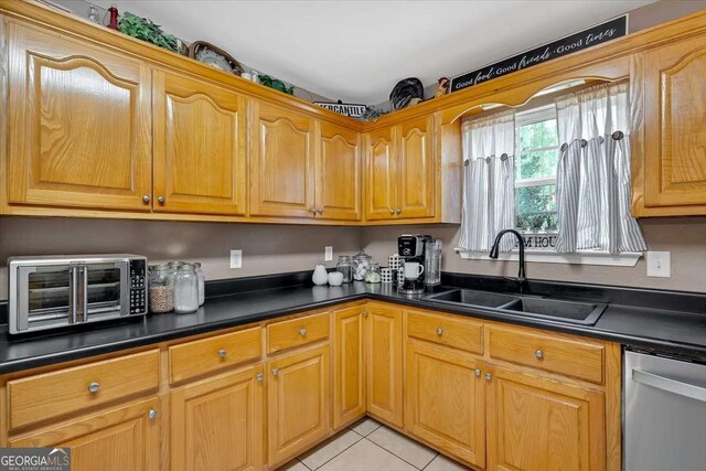 kitchen with sink, light tile patterned floors, and dishwasher