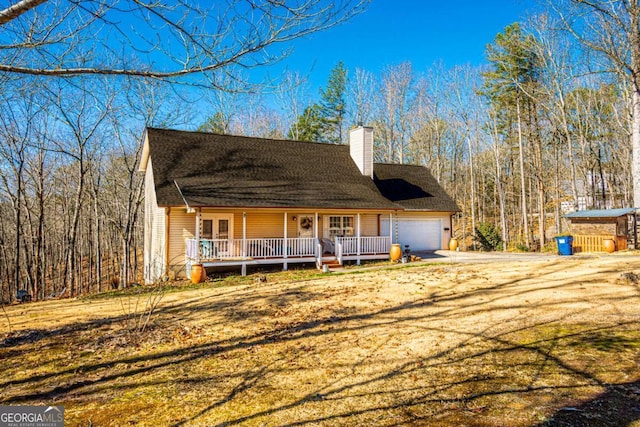 view of front of house with a porch, a garage, and a front lawn