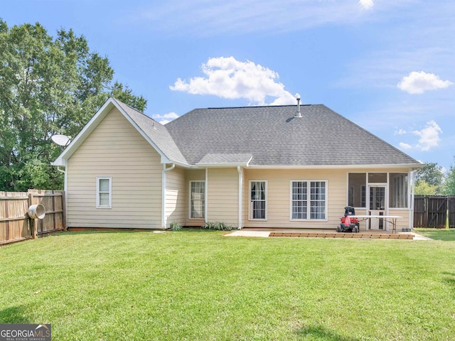 rear view of house featuring a patio, a sunroom, and a lawn