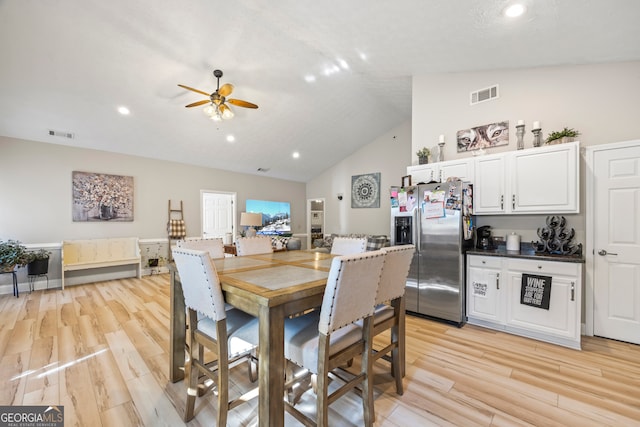 dining area with ceiling fan, high vaulted ceiling, and light wood-type flooring