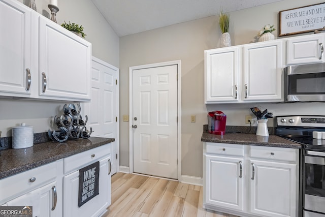 kitchen with white cabinetry, stainless steel appliances, and light wood-type flooring