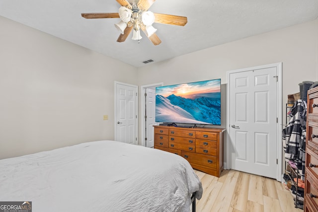 bedroom with light hardwood / wood-style floors and ceiling fan