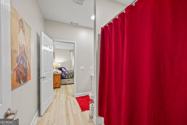 hallway featuring a textured ceiling and light hardwood / wood-style floors