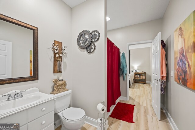 bathroom with vanity, hardwood / wood-style floors, and toilet